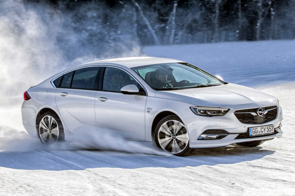 Opel Insignia Grand Sport bianca su neve drifting, si vede la coppia motrice e relativa distribuzione sulle 4 ruote.