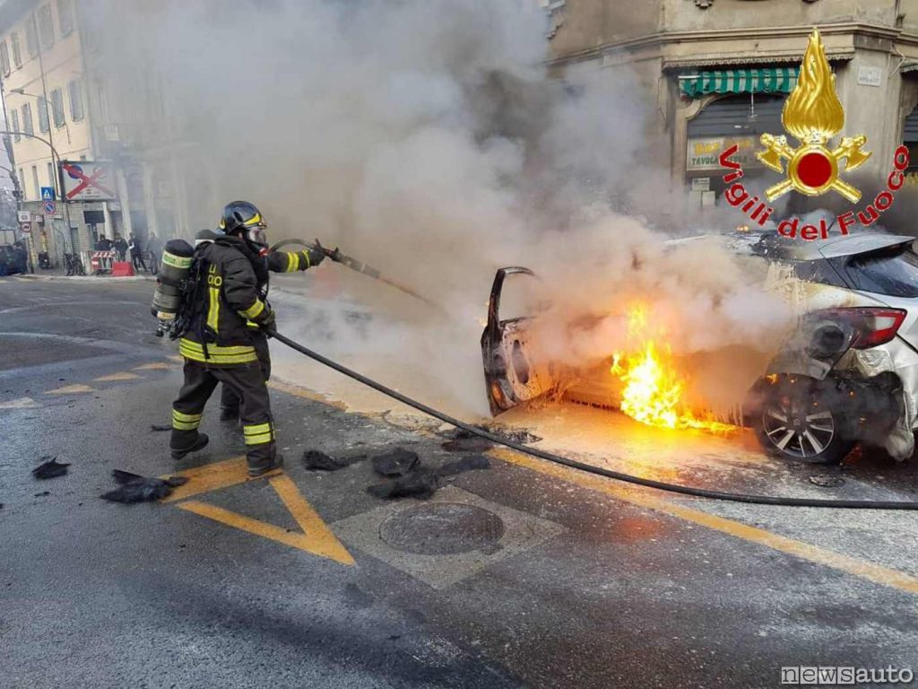 L'acqua dall'idrante sotto pressione utilizzata dai pompieri per domare l'incendio di un'auto