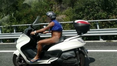 Uomo nudo sullo scooter in autostrada
